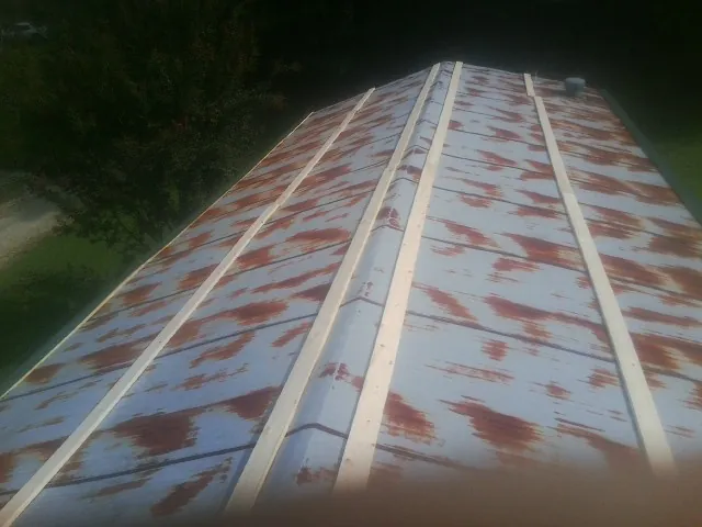Rusted metal roof panels with new wood purlins before replacement — Storm Damage Roof Repair in Saint Albans by Roofing Brothers
